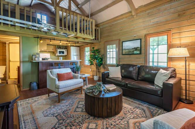 The living room inside the Hilltop Cabin, with a vaulted timber ceiling