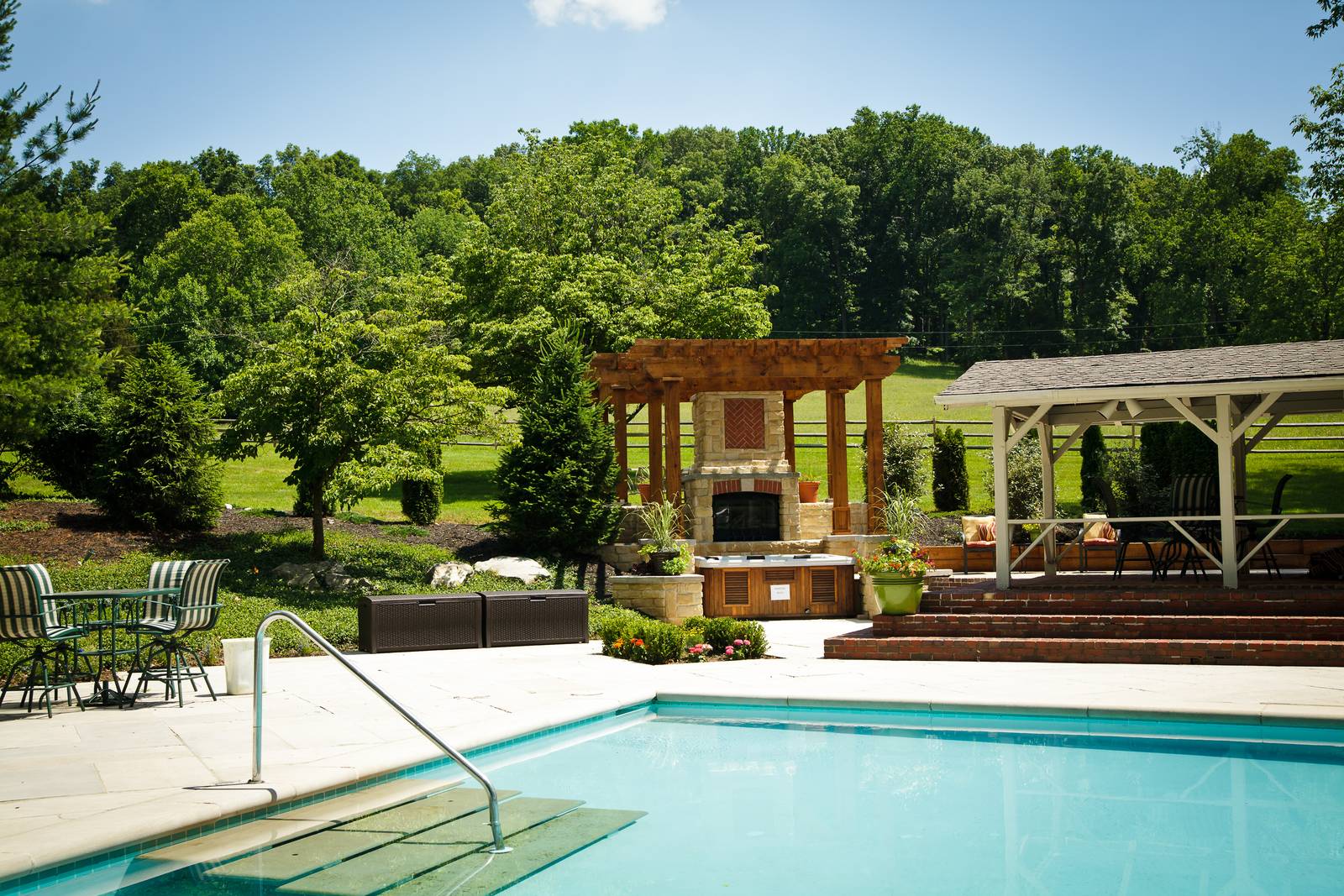 The Jr. Olympic pool at the estate, with the pergola and outdoor fireplace beyond