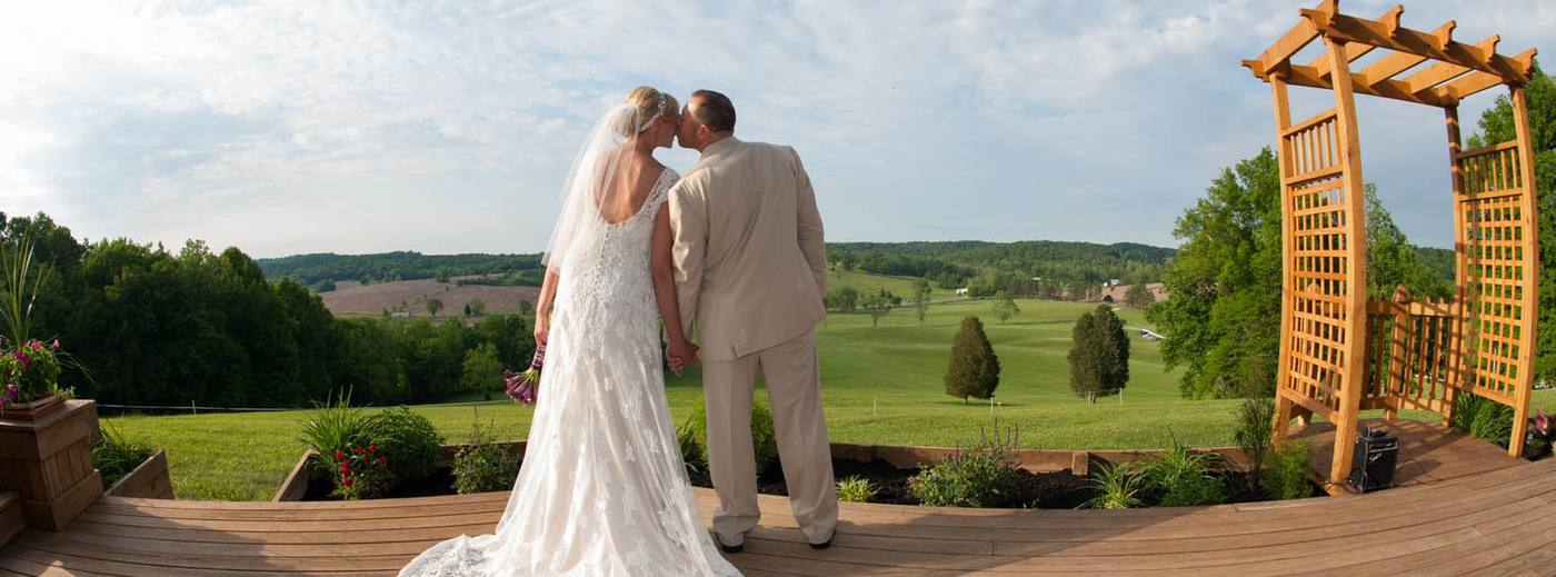 A couple beneath the hilltop arbor