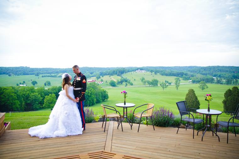 A bride and groom facing each other on the hilltop deck