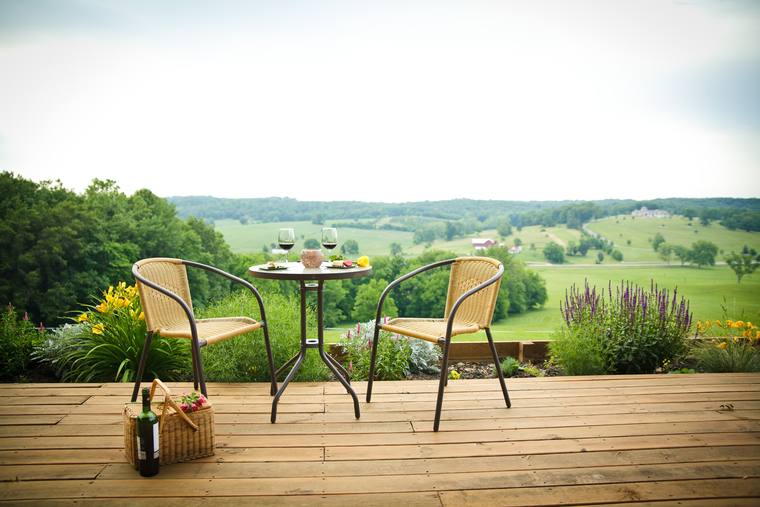 A table set for two on the hilltop, wine poured, valley beyond
